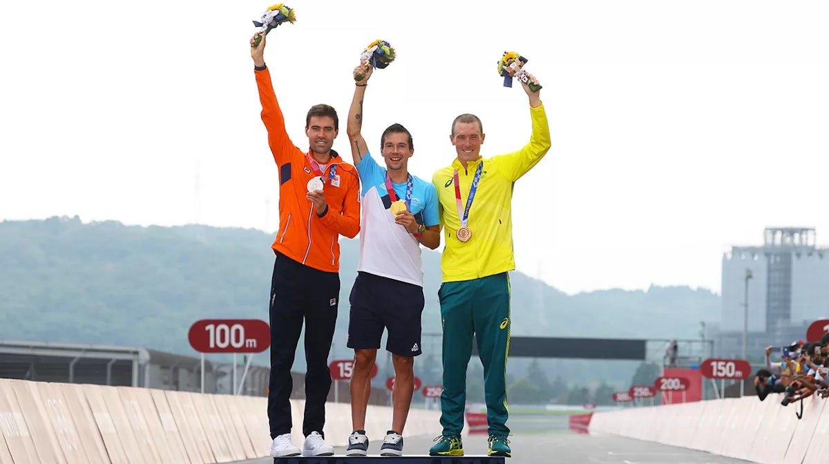 Silver medalist Tom Dumoulin of Team Netherlands, gold medalist Primoz Roglic of Team Slovenia, and bronze medalist Rohan Dennis of Team Australia, pose on the podium during the medal ceremony after the Men's Individual time trial on day five of the Tokyo